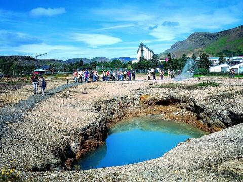Hveragerði. Á myndinni er hverahola. Hveragerðiskirkja er í baksýn.